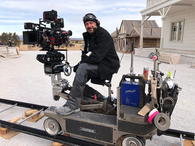 man sitting on camera dolly