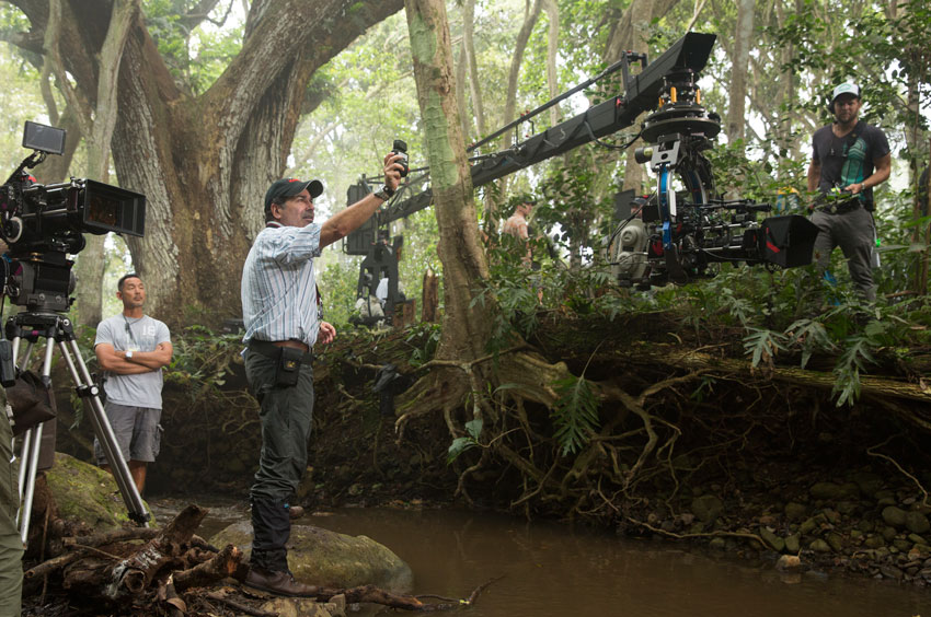 Cinematographer Jon Scwartzman behind the scenes of Jurassic World prepping a shot in a forest.