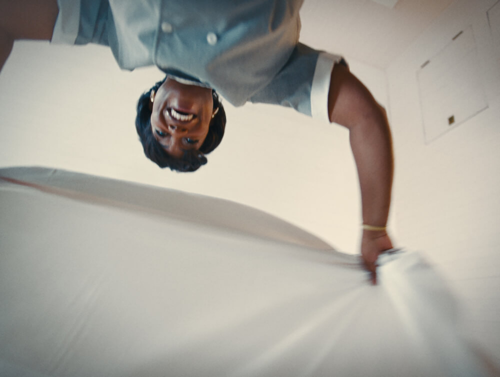 An artistic upside-down portrait shot of actress Aunjanue Ellis-Taylor (as Hattie) smiling warmly against a soft, blurred background