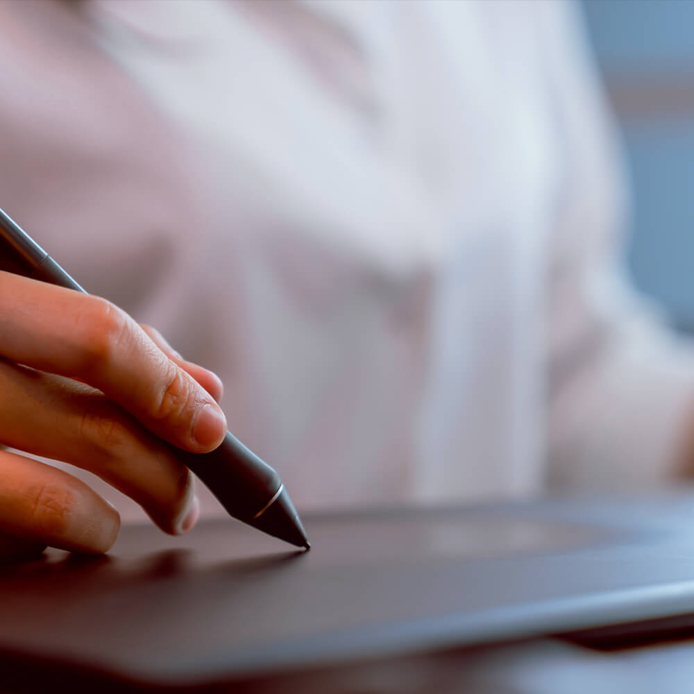 hand holding stylus against track pad tablet