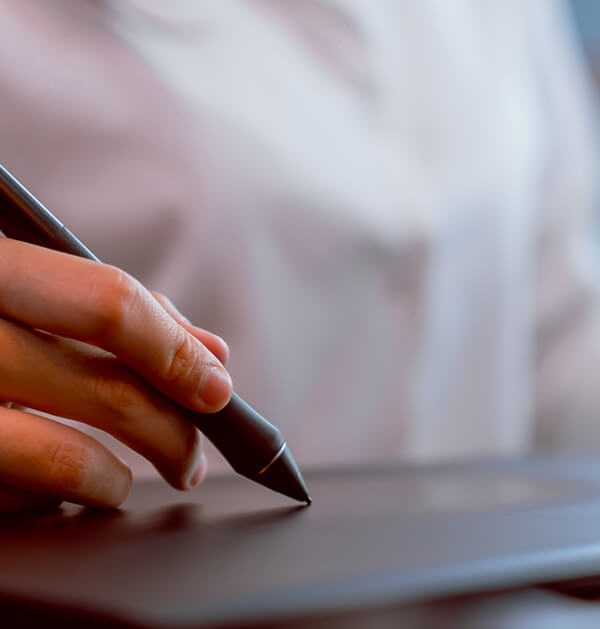 hand holding stylus against track pad tablet