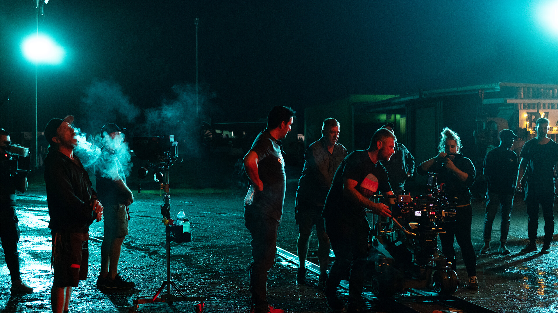 Film set lit by two large lights in the distance